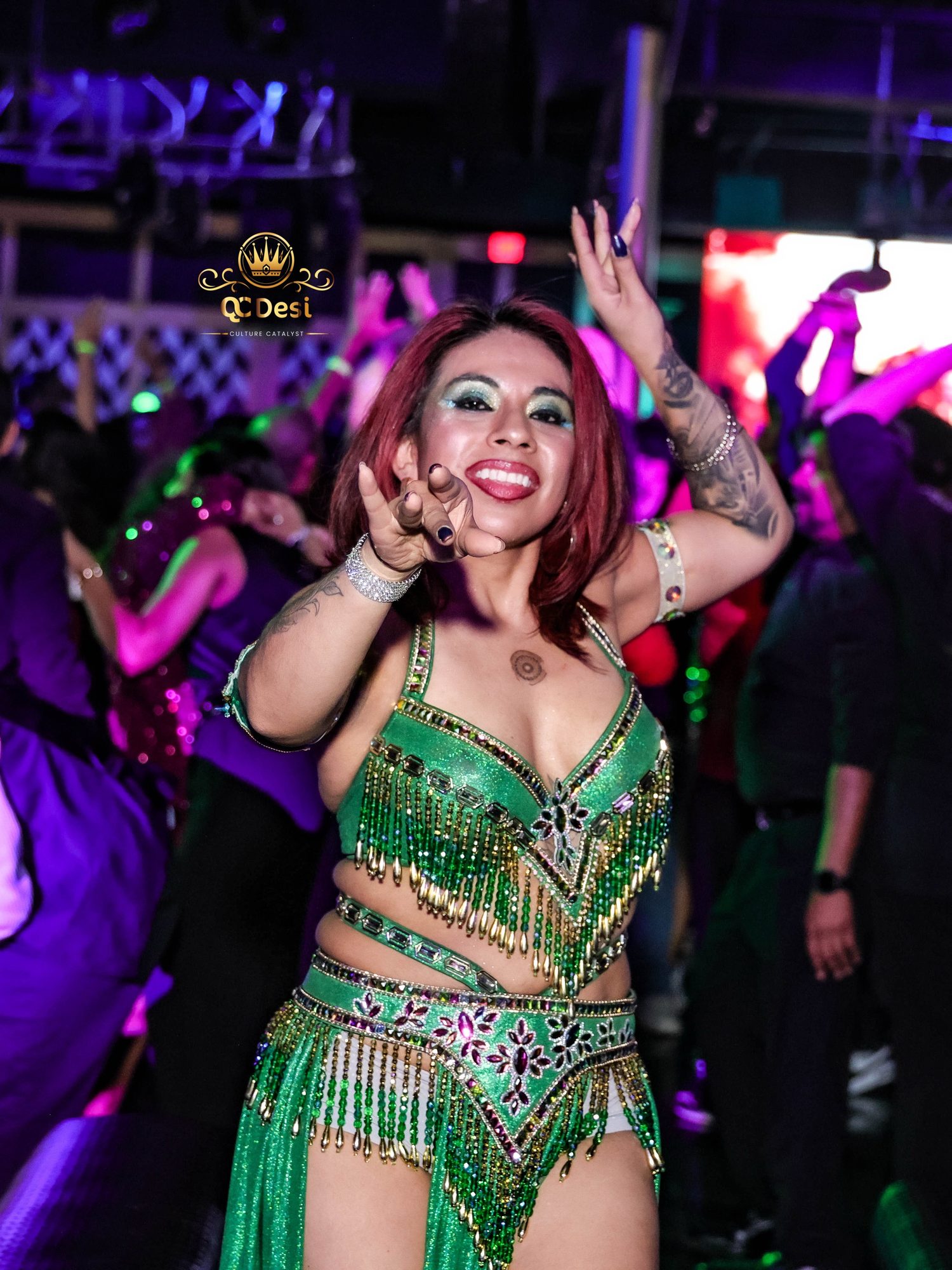 Performer in a green sequinned outfit dancing in the crowd