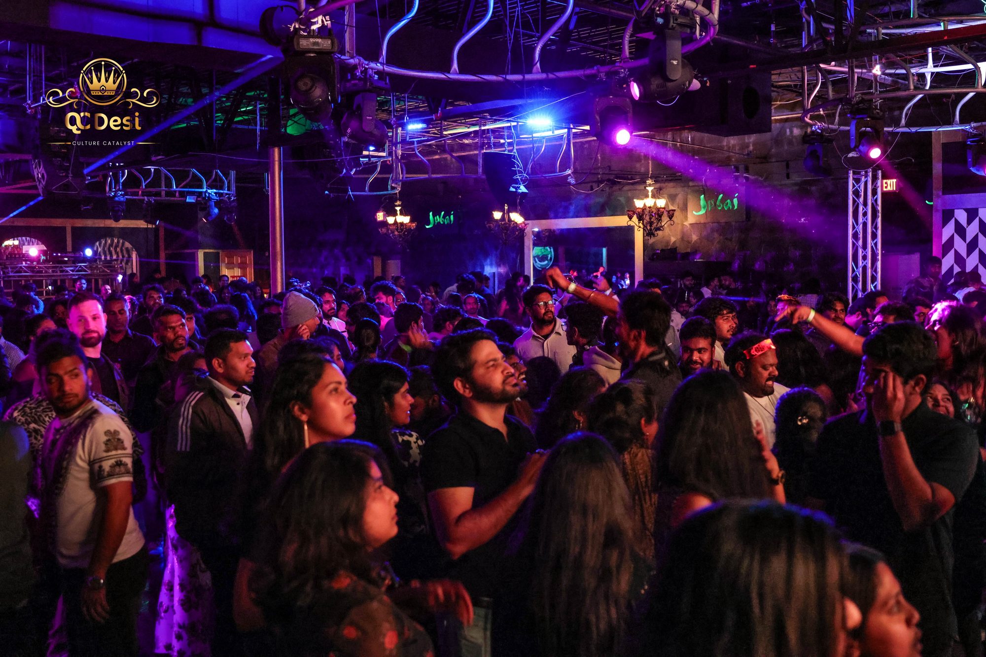 Crowd dancing under purple lights